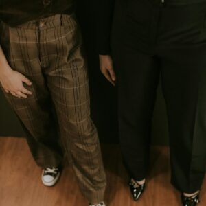 A stylish pair showcasing trendy pants and footwear with a warm indoor ambience.