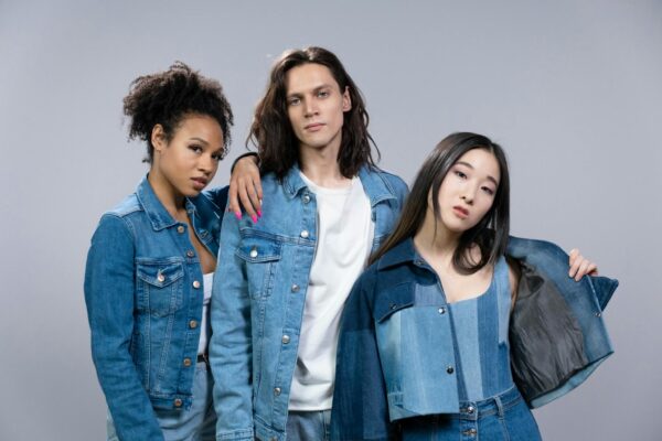 Trendy young adults in denim outfits showcasing diversity and modern style in a studio portrait.